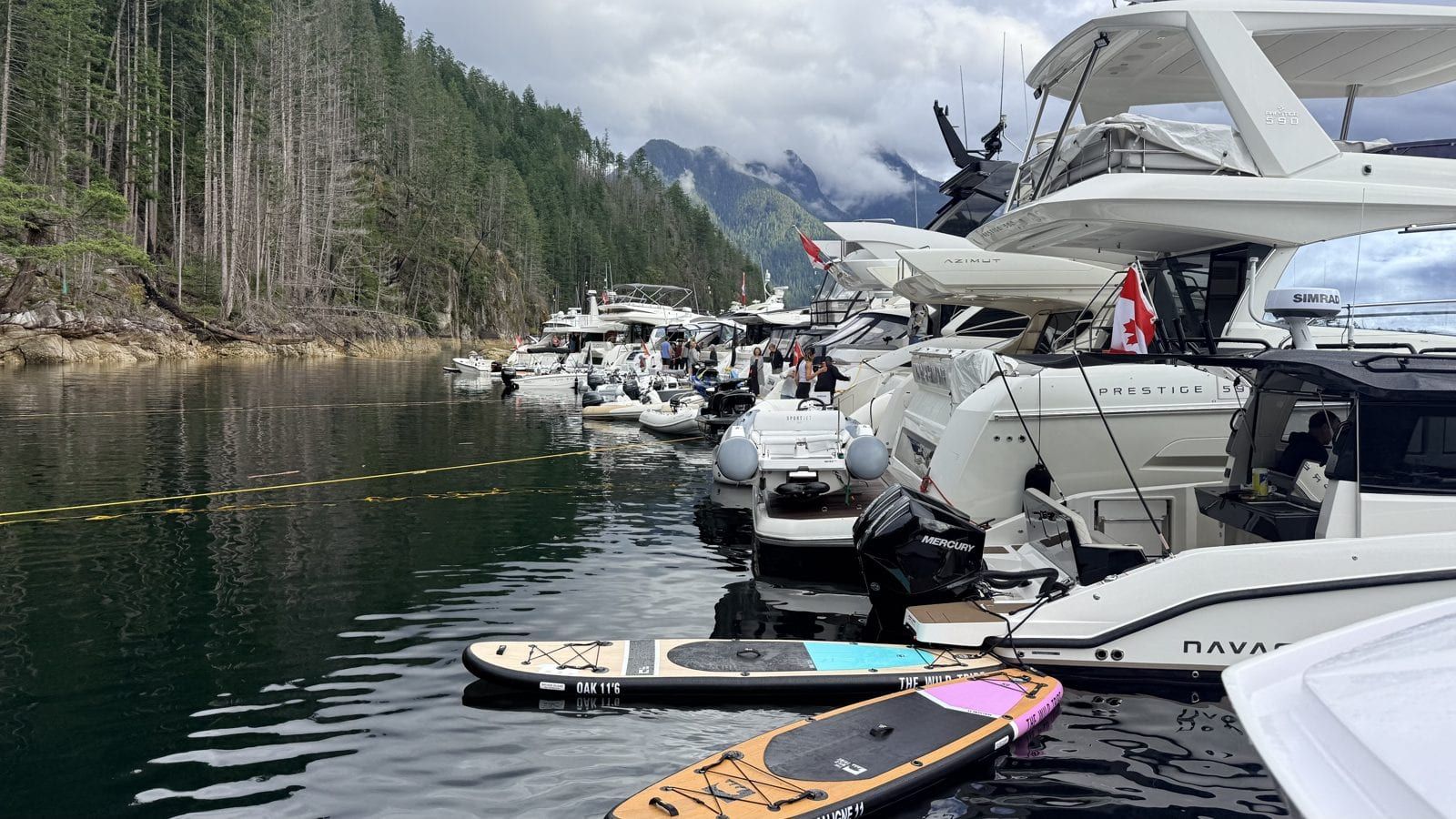 BC Day long weekend raft-up — a dozen yachts stern-tied in the fjord, dinner set up on the float