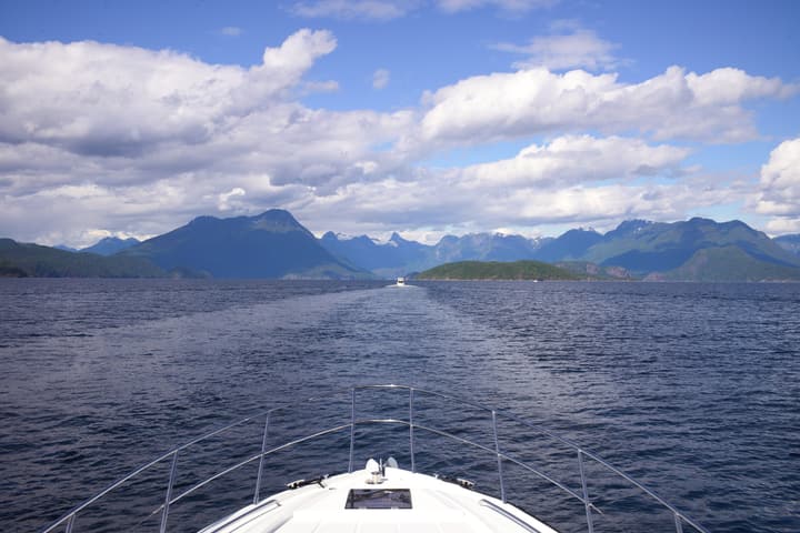 Looking over the bow at calm water and mountains