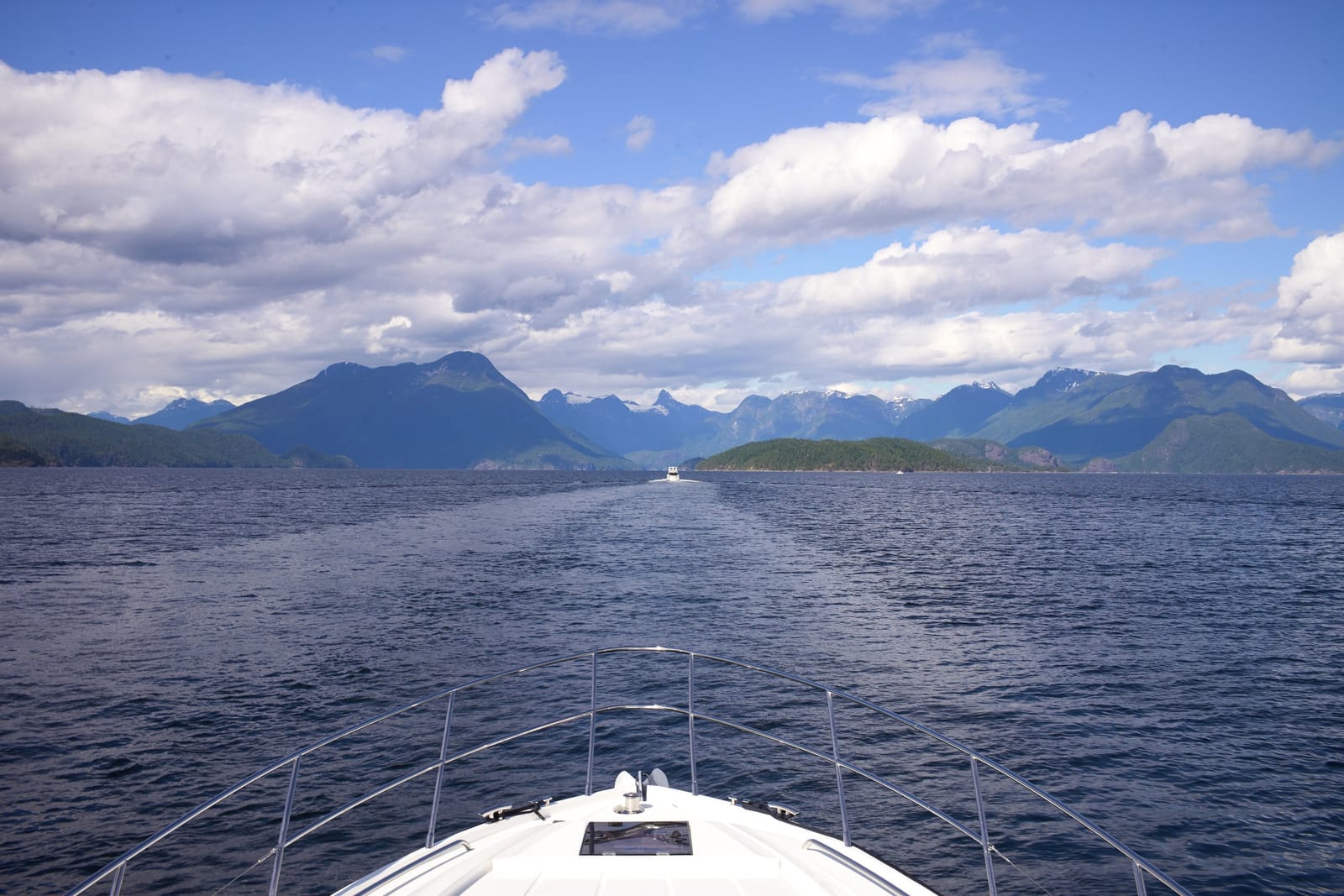 Looking over the bow at calm water and mountains